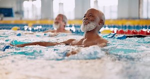 Dumbbell, fitness and man in swimming pool for training, health and strong muscle. Weight, water and aerobics class for exercise, physical therapy or rehabilitation of happy senior group in lesson