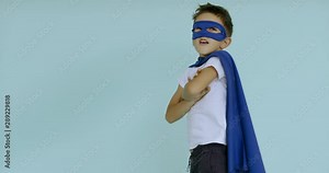 120 FPS SLOW MOTION Cute little Caucasian kid boy wearing blue cape and mask, pretending to be a superhero. 4K UHD Stock Video