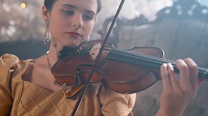 A woman in a gold dress playing the violin