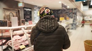 Aged woman pushing cart in retail store for groceries