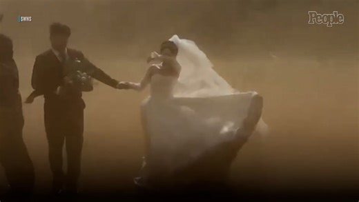 Bride and groom caught in sudden sandstorm while taking their wedding photos