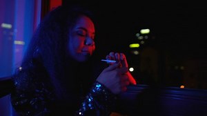 High woman smoking weed joint at night private party, drug addiction, relax