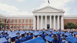 Graduation ceremony with graduates wearing blue caps and gowns