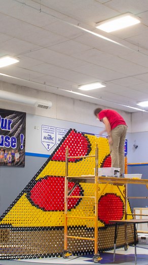 Most dominoes toppled in a 2D pyramid - 8,122 by Steven Price, Christopher Wright, Michael Fantauzzo, Matt VanVleck, Alex Koops, Derek Koops, Paul Nelson, Stephan Burton 🇺🇸 and Timothy Dunsmore 🇨🇦 | Guinness World Records