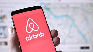 Airbnb logo on a smartphone and on the background the website on a computer monitor.MONTREAL CANADA APRIL 2021