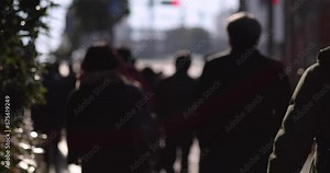 A slow motion of walking people on the city street defocused
