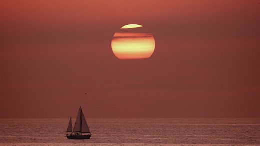 View of the horizon in the sea while a sailboat sails - Free Stock Video