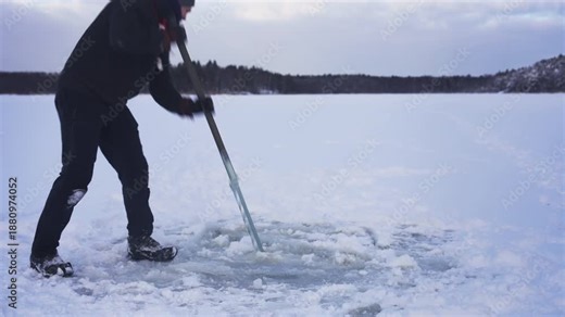 Cutting an Ice Hole on a Frozen Lake with Ice Saw