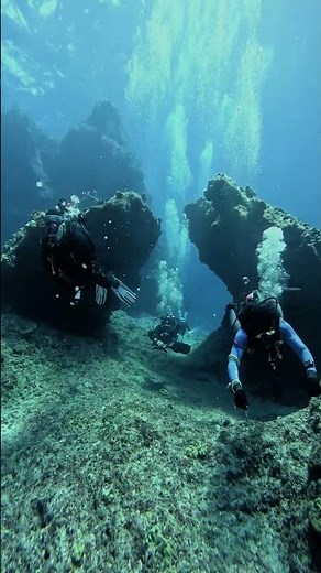 Scuba Divers Exploring Underwater Coral Caves