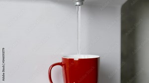 Pouring water from a water purification device into a glass. 4K