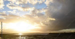 time-lapse of storm clouds rolling in over coastal water at sunset