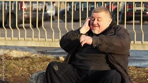 A fat man talking on the phone and very nervous on city street.