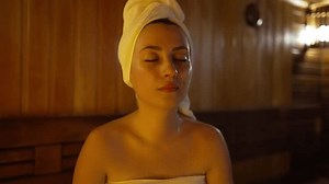 Young woman sweating in sauna