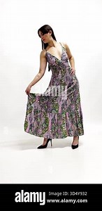 Backstage of studio shooting: Brunette model with fashion outfit posing for photographer and stylist