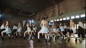 Young women performing modern dance. Group of stylish young women dancing indoors. Graceful dancers performing sensual dance routine. Heels. Synchronized dance of female. Youth culture. 4K, UHD