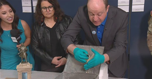 Gov. Jared Polis opens box from 1907 found underneath statue at Colorado State Capitol
