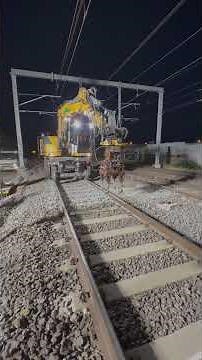Hi-Rail excavator using tamping head attachment on railway track