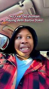 A 40 year old woman playing with Barbie dolls.