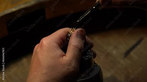 master of jewelry manually inserts gems into the frame of future jewelry. Working desk for craft jewelry making with professional tools. diamond ring on the jeweler's desktop