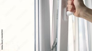 Classic PVC window in work, hand open and closing the window