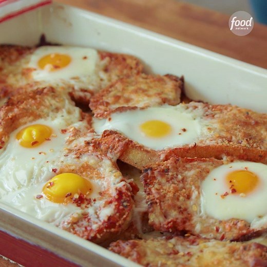 Layers of buttery garlic toast, sauce and cheese turn into a strata topped with yolky eggs! 😍🍳 #ad Get the recipe: https://foodtv.com/2FQa8tK | Food Network