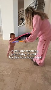 f your baby wants to walk but keeps dropping to the floor, try this. A hula hoop gives them something stable to hold while they practice stepping forward. It helps with balance, confidence, and coordination without you pulling on their arms. Stand behind them or in front of them, let them grip the hoop, and gently guide it forward as they step. Most babies feel safer holding something wide and steady instead of just hands. This is such an easy way to support walking without pressure and you prob