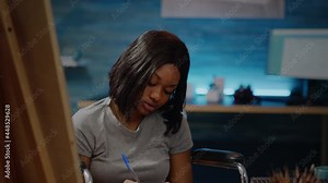 Portrait of african american woman with disability drawing sketch for fine art project. Black paralyzed artist sitting in wheelchair preparing for modern masterpiece. Artistic hobby