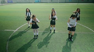Stylish Young Women in Synchronized Pose on Sports Field