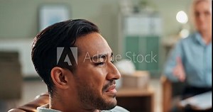 Sad man, crying and talking with therapist for stress, anxiety or depression in mental health at clinic. Closeup of young male person with psychologist or shrink to cope with emotion, grief or loss
