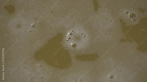 Liquid of sugar cane being fermented on a process to make Cachaça