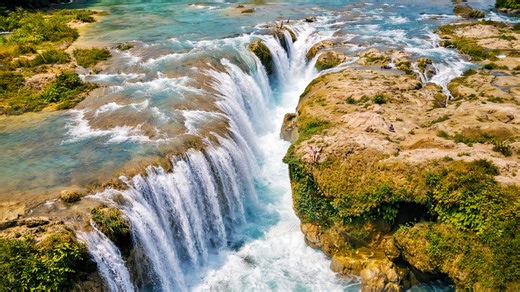 The waterfall where turquoise water flows in multiple streams