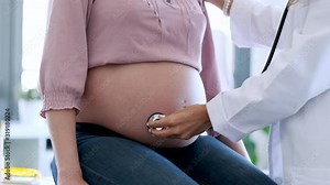 Woman gynecologist checking the heartbeat baby of her pregnant patient in the clinic.