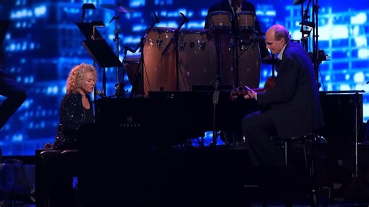 Carole King and James Taylor’s duet on “Will You Still Love Me Tomorrow” is a moving meeting of two of popular music’s most enduring voices. Originally written by King with lyricist Gerry Goffin, the song was first recorded by The Shirelles in 1960 and became the first No. 1 hit by a Black all-girl group on the Billboard Hot 100. King later reinterpreted it herself on her landmark 1971 album Tapestry, giving the song a slower, more introspective quality. When performed with James Taylor, the son