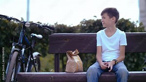 Anticipation in the Park: Boy Waiting on Bench, Gazing at Watch with Eagerness