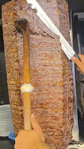 Cutting a piece of grilled meat with clean and even slices