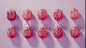 Pink lollipops, candies, bonbons on purple background. Summer bright texture studio shot for store, supermarket, close up top view, zoom. Children's favorite sweets made of sugar. Stock Video