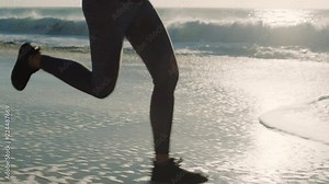 woman runner legs running exercising fitness workout sprinting female feet splashing water on wet beach slow motion