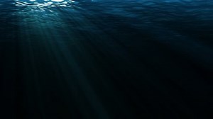 Dark underwater scene with waves and sun lights