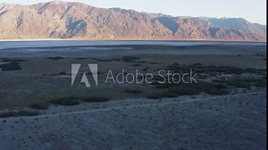 Drone flying low over rugged and harsh terrain valley at Death Valley National Park, California.