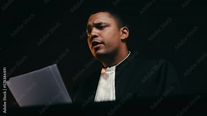 Male judge listening witness, asking questions and reading case materials, trial