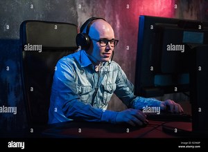 He like play and win video games. In blue light of display emotional man play computer games online Stock Photo - Alamy