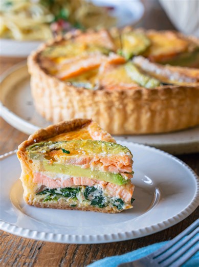 レシピはキャプションで👇️ 【絶対褒められる】春の彩り、サーモンとアボカドのキッシュ。/Salmon & Avocado Quiche ■調理時間目安:120分 ■材料:3-4人分 ◯冷凍パイシート(11×18cm) 2枚 【A】オリーブオイル 大さじ1 【A】玉ねぎ 1/4個 【A】塩 ひとつまみ ◯ほうれん草 60g 〈B〉卵 4個 〈B〉生クリーム 50ml 〈B〉粉チーズ 15g 〈B〉塩 3g 〈B〉あらびき黒こしょう 適量 ◯サーモン 200g ◯アボカド 1個 ◯クリームチーズ 100g ■作り方 《生地》 ①冷凍パイシートは常温で10分ほど置いて、解凍しておく。 ②パイシートをめん棒で伸ばし、タルト型に敷き詰め、フォークで底に穴を数カ所空ける。 ③アルミホイルを②に被せ、タルトストーンをのせる。 ④170℃に予熱したオーブンで50分焼く。 《キッシュの仕上げ》 ［下準備］玉ねぎとアボカドは薄切りにする。ほうれん草はザク切りにする。サーモンは塩をふり、冷蔵庫で10分程度おいてから水で洗い、水気を拭き取る。 ①フライパンに【A】を入れ、玉ねぎがしんなりするまで弱火で炒める