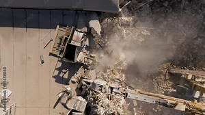 Building demolition excavator using Pulverizer Jaws to demolish a residential building