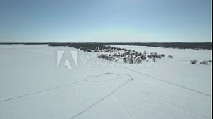 Finland's and Sweden's beautiful Tornio river at winter. Snowmobiles passing by and people ice fishing.