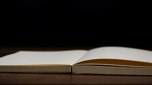 Download 4K-Slow motion of open book with blank page fallowing on wooden table with black background, Education and business concept. for free