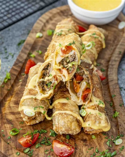Crispy, golden Beef Taco Egg Rolls loaded with juicy, seasoned beef, melty cheddar, fresh cilantro, and a little crunch from cherry tomatoes—all wrapped up and fried to perfection. Recipe link in comments 👇 | JoCooks