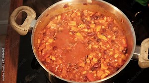 Time lapse of a tomato bean dish as it simmers with occasional stirring. Lid on and off. Very wholesome vegan and plant based food cooking process.