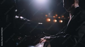 Close-up of professional pianist play the piano. Male pianist playing classical piano on stage in a hall