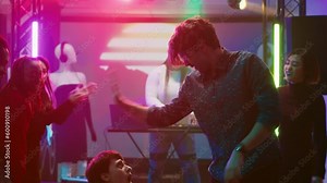 People starting fun dance battle at club, having fun together at party with electronic music. Talented confident persons creating breakdance battle at nightclub event. Tripod shot.