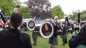 Drum Major Ian Esson (on bass drum) and Pipe Major James Cooper lead Ballater & District Pipe Band, playing "Murdo's Wedding", "Lord Lovat's Lament" and "The Old Rustic Bridge" on Ballater Green in June 2019. This was part of the 2019 Ballater Duck Festival, an event created after flooding in the town a few years before, which raises funds to help with the renovation and raise a smile. The event includes a race along the river Dee using giant inflatable ducks, the winning one being paraded throu
